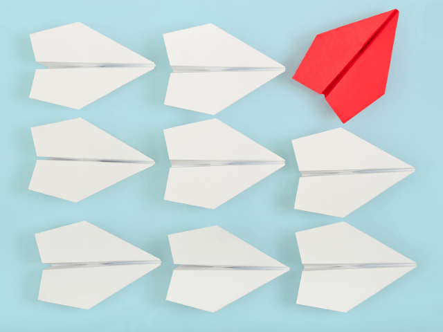 Stand out in crowd with white paper airplanes and one red one.