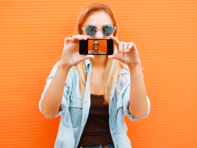 Instagram alternative app for bloggers with influencer holding up phone.