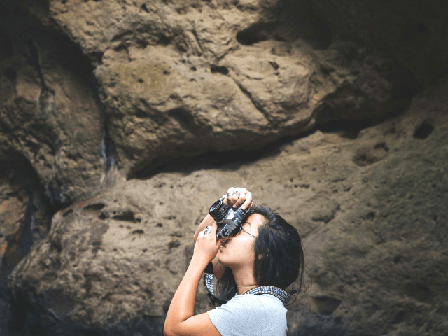 Ways to stand out from the crowd. Blogger taking photo with black camera.